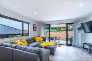 a living room with a gray couch and yellow pillows at Kirimoko Family Retreat in Wanaka