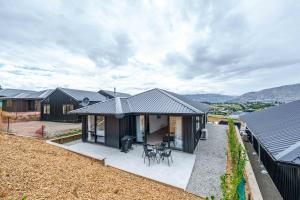 a house with a black roof and a patio at Kirimoko Family Retreat in Wanaka