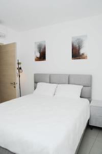 two beds in a bedroom with two pictures on the wall at The best location in Jerusalem 1 in Jerusalem