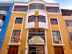 HOTEL LOS ANDES SUITE في تروخيو: مبنى اصفر عليه علامة الفندق