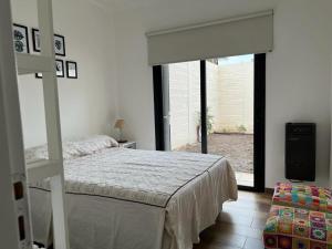 um quarto com uma cama e uma grande janela em Departamento en Bragado A em Bragado