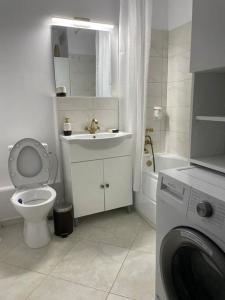 a bathroom with a toilet and a sink and a washing machine at Apartament Bucuresti Bucharest in Bucharest