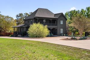 a large black house with a driveway at Hot Tub + Fire Pit + Pool + Game Room ~ Guesthouse in Manor