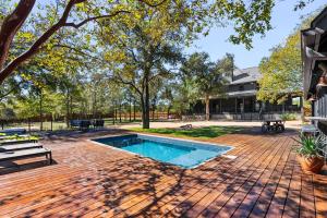 a backyard with a swimming pool and a house at Hot Tub + Fire Pit + Pool + Game Room ~ Guesthouse in Manor