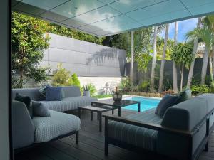 努美阿的住宿－Villa de Standing à Nouméa，带沙发和桌子的庭院以及游泳池。
