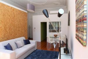 Home At Porto - Bolhão Apartments في بورتو: غرفة معيشة مع أريكة بيضاء وطاولة