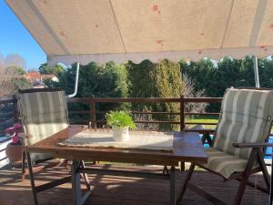 two chairs and a wooden table on a deck at Family's home Trikala in Tríkala