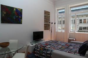 Home At Porto - Bolhão Apartments في بورتو: غرفة معيشة مع طاولة وتلفزيون