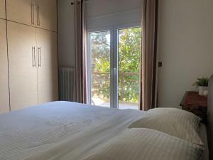 a bedroom with a white bed and a large window at Family's home Trikala in Tríkala +19 photos