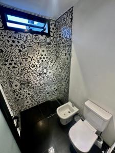La salle de bains est pourvue de toilettes et d'un mur noir et blanc. dans l'établissement Casa del cerro 1 - Three Houses, à La Rioja
