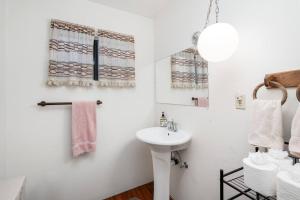 een witte badkamer met een wastafel en een spiegel bij Escape to the Cabin, in Plumas National Forest 