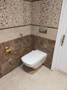 a bathroom with a toilet in a tiled wall at شقة مفروشة مدينة نصر in Cairo