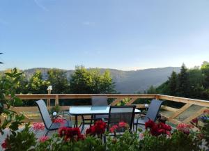 a patio with a table and chairs and flowers at Cabana Lupul din Apuseni in Mătişeşti