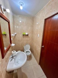 HOTEL LOS ANDES SUITE في تروخيو: حمام مع حوض أبيض ومرحاض