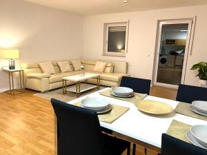 sala de estar con mesa y sofá en Moderne Ferienwohnung in Leimen mit Balkon, WeHome Komfort, en Leimen