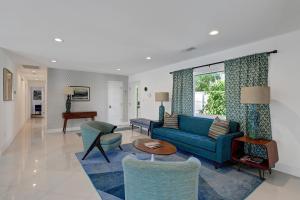 uma sala de estar com um sofá azul e cadeiras em Ultra-Luxury Mid-Century Alexander Pool 3BD/3BATH em Palm Springs