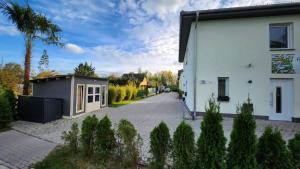 a house with a small garage next to a street at Ferienwohnungen Im Grund 22, 22a, 22c Birkenstein in Hoppegarten