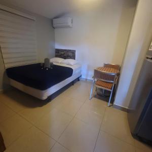een slaapkamer met een bed en een stoel erin bij Always Summer Inn in Culebra