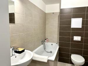 La salle de bains est pourvue d'un lavabo, d'une baignoire et de toilettes. dans l'établissement Sky Apartments 505, à Plzeň