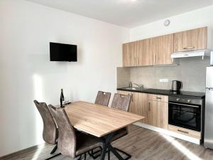 - une cuisine avec une table en bois et des chaises dans l'établissement Sky Apartments 505, à Plzeň