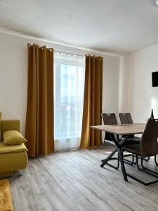 d'un salon avec une table, des chaises et une fenêtre. dans l'établissement Sky Apartments 505, à Plzeň