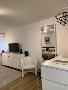 a white room with a mirror and a white chair at Eine schöne Wohnung am Messeplatz in Basel