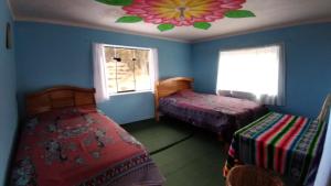 Ocosuyo的住宿－Dawn House，一间卧室设有两张床和花卉天花板