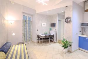a living room with a table and a kitchen at La Vie en Rose in Cuneo