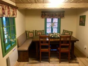 comedor con mesa, sillas y ventana en Chalupa Řeka - Na samotě u lesa en Řeka