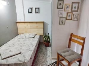 a small bedroom with a bed and a chair at Casa IWANA in Guayaquil