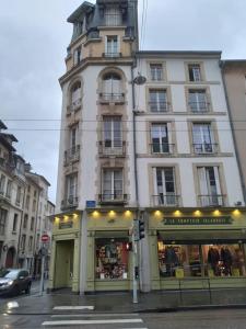 ein hohes Gebäude in einer Stadtstraße mit einem Geschäft in der Unterkunft Cosy and calm apartment in the center of nancy in Nancy
