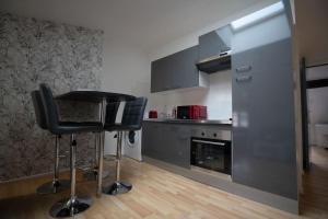 eine Küche mit einem Barhocker in der Mitte einer Küche in der Unterkunft Cosy and calm apartment in the center of nancy in Nancy