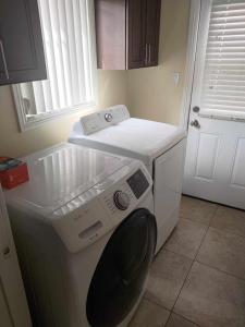 eine Waschmaschine und einen Trockner in einer Küche mit Fenster in der Unterkunft Secluded Gem in South Gate