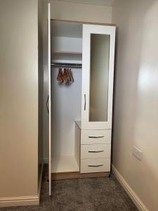a closet with a mirror and a white cabinet at Entire 2BR Cosy Home Thornaby in Thornaby on Tees
