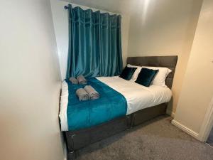 a bed in a room with a green curtain at Entire 2BR Cosy Home Thornaby in Thornaby on Tees