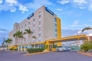 ein Hotel mit einem weißen Van davor geparkt in der Unterkunft City Express by Marriott Hermosillo in Hermosillo