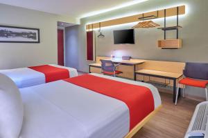 a hotel room with two beds and a desk at City Express by Marriott Hermosillo in Hermosillo