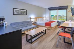 a hotel room with a bed and a couch at City Express by Marriott Hermosillo in Hermosillo