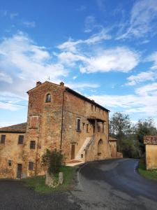 un vecchio edificio di mattoni con una strada davanti di Casa Zeno a Volterra