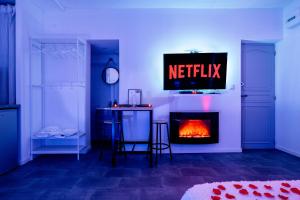 ein Wohnzimmer mit einem TV und einem Kamin in der Unterkunft Suite Romantique in Sault-de-Vaucluse
