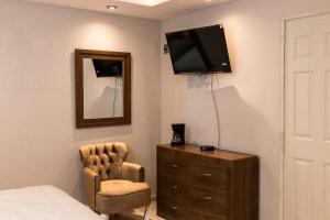 瓜納華托的住宿－Hotel Arthemisa，一间卧室配有一张床、一把椅子和镜子