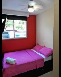 a bedroom with two beds with pink sheets and a window at R.3-3 Lindo estudio, 2 habitaciones en el ciudad de Panamá. in Panama City