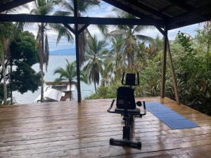 a chair on a wooden deck with a view of the ocean at Ponci’s Gate to Gaia Holistic Center in Bocas del Toro
