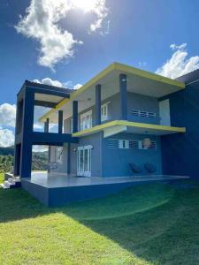 a blue and white house with two chairs in the yard at Apartamento El Secreto in Canovanas