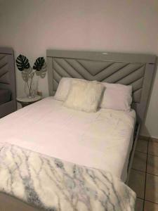 a bedroom with a white bed with a headboard at Apartamento El Secreto in Canovanas
