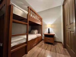 a bedroom with two bunk beds and a lamp at Perfect family 2-bed Condo with hot tub in Dead Man's Flats