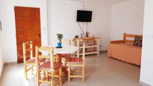 ein Wohnzimmer mit einem Tisch, Stühlen und einem Bett in der Unterkunft DPTO Bahia in Bahía Blanca