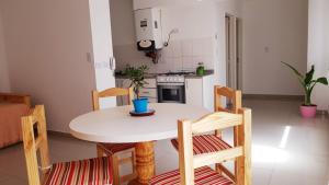 eine kleine Küche mit einem weißen Tisch und Stühlen in der Unterkunft DPTO Bahia in Bahía Blanca