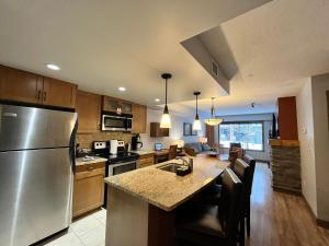 a kitchen with a stainless steel refrigerator and a counter at Perfect family 2-bed Condo with hot tub in Dead Man's Flats
