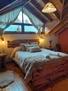 a bedroom with a large wooden bed with a large window at Tierras del Sur II in Villa La Angostura